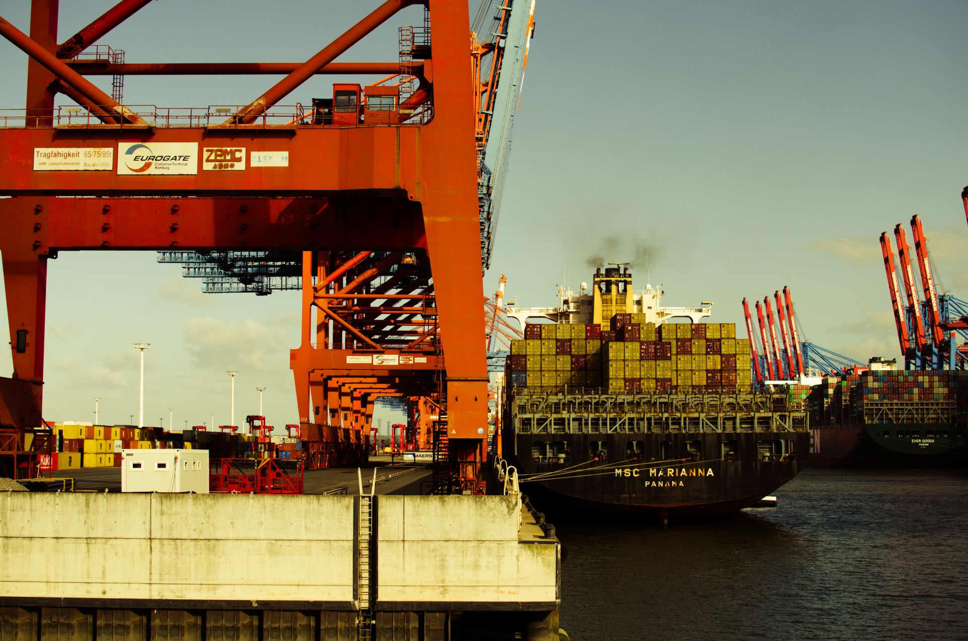 Container ship and cranes alongside a cargo terminal